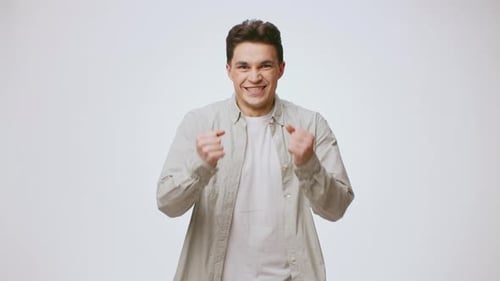 Happy Young Man Gesturing Success and Crossing Arms