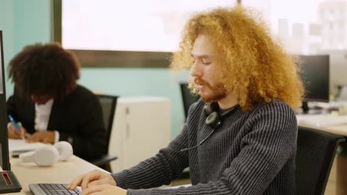 Homme moderne souriant tout en travaillant dans un espace de coworking