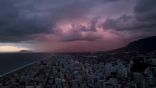 Coastal Cityscape Under Stormy, Dramatic Night Sky