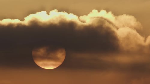 Die Sonne wird in der Abenddämmerung von Wolken verdeckt