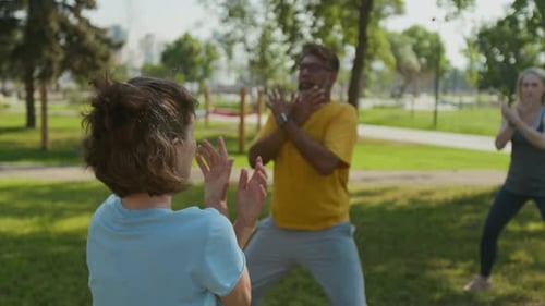 Group Exercise Class Outside in Green Urban Park