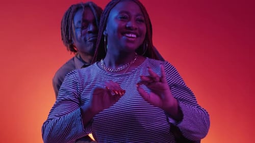 Young Couple Dancing Together in Studio with Neon Lighting