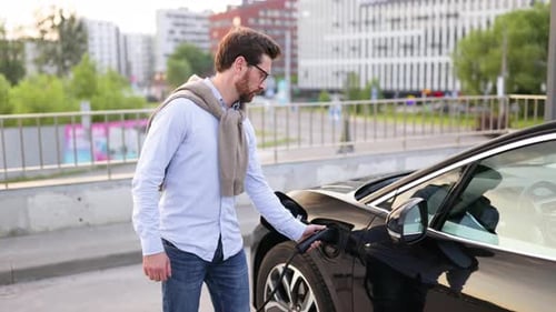 Man Charges Electric Car Giving Thumbs Up