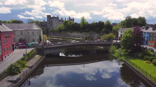 Aerial footage of medieval town, castle and arch bridge while decreasing attitude.