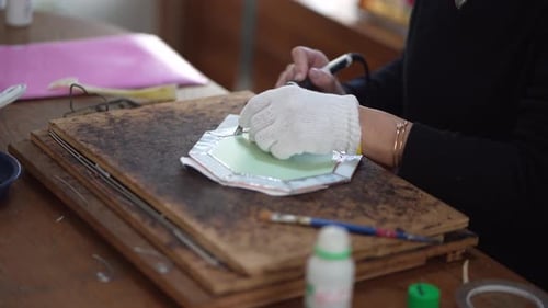 A woman making a stained glass work