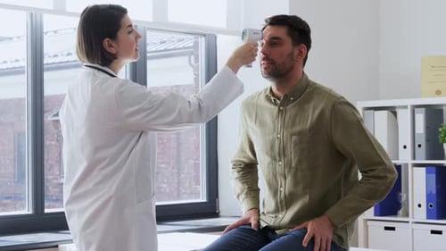 Doctor taking temperature of man with touchless thermometer
