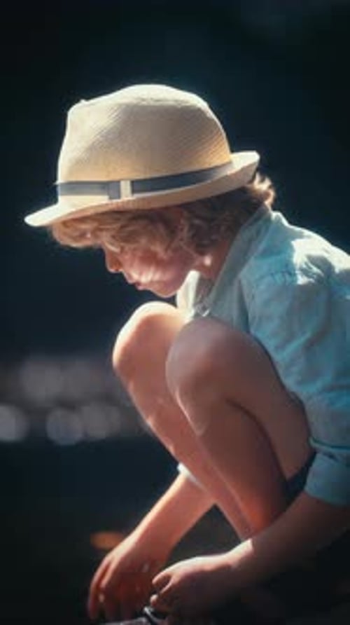 Side View Of A Young Boy Sitting By The Creekside
