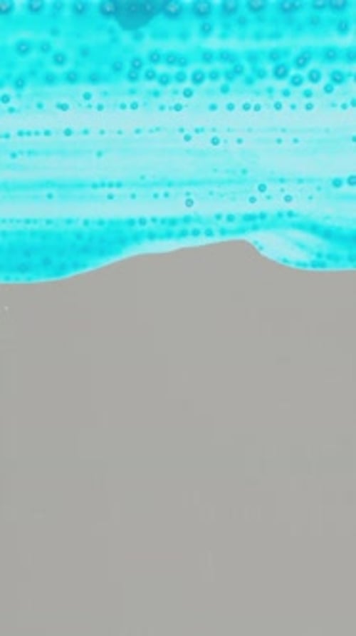 Vertical video. The entire screen is filled with blue paint using a painting brush. Close-up