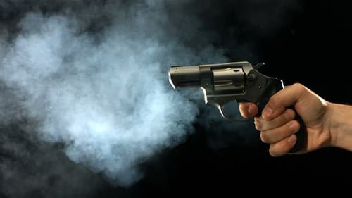Revolver, der Rauch und Feuer in Zeitlupe abfeuert und Macht und Gewalt zeigt