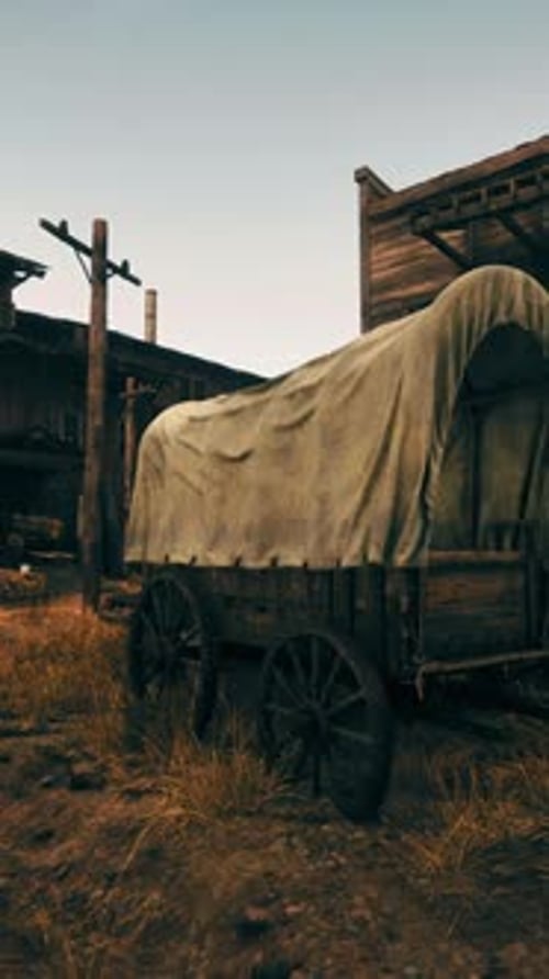 Un vagón cubierto frente a un edificio rústico de madera