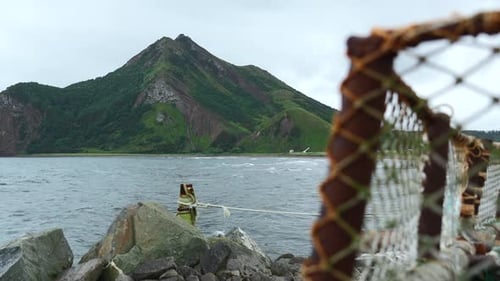 Abandoned fishing boat on background of rocky coast. Clip.