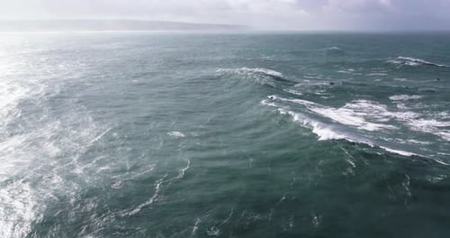 Aerial drone shot of big wave surfer surfing a wave on a day with giant waves in Nazare, Portugal,