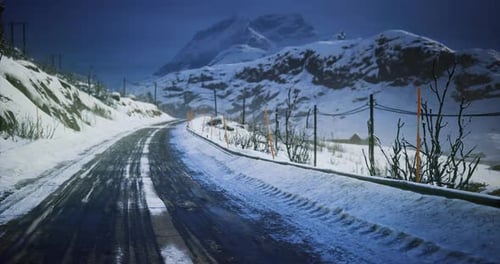 Snow Covered Road Winding Through Mountain Landscape During Twilight