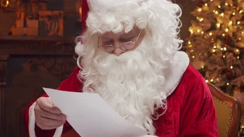 Santa Claus's Workshop Santa is Busy Wrapping a Gift at the Table with a Fireplace and Christmas