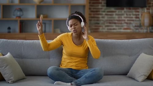 Woman Listens to Music and Sings on Couch