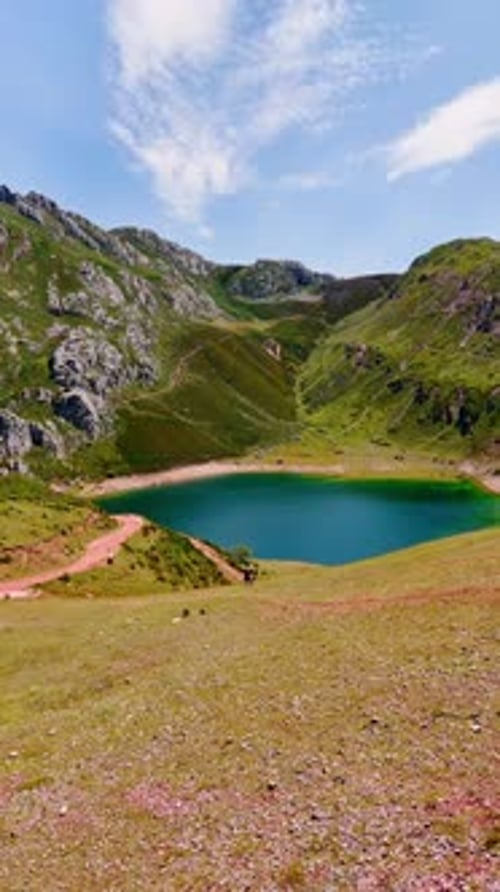 Beautiful turquoise lake located in the mountains. A couple stands watching the wonderful scenery