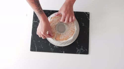 Woman Baker Puts an Almond Cake Piece Into the Cream in the Rubber Form