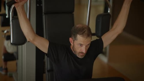 A Focused Man Lifting Weights with Determination in a Modern Stateoftheart Gym Facility
