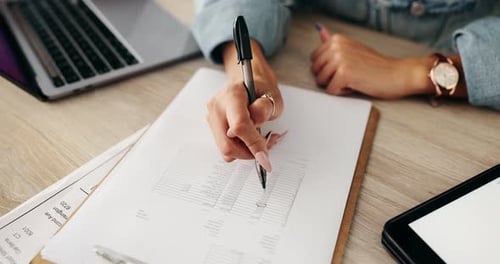 Woman Edits Document at Office Desk