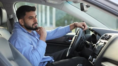 Young Adult Man Pensively Sitting in a Car