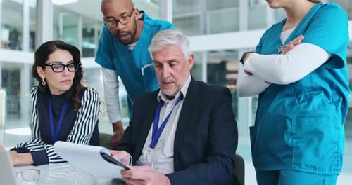 Medical Team Collaborating on Documents in Modern Office