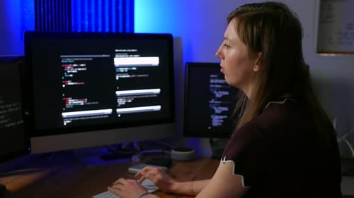 Young artificial intelligence computer code programmer working in a programming office with multiple