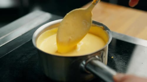 professional cuisine: the chef prepares a sauce based on cheddar cheese and cream