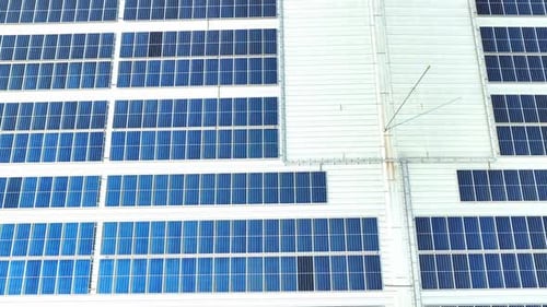 An aerial view reveals a solar panels blanketing the building's roof.