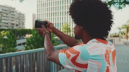 shooting use smartphone stands on bridge on urban street background