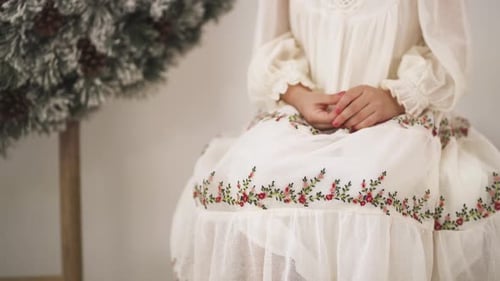 Girl in White Dress Sitting Near Christmas Tree