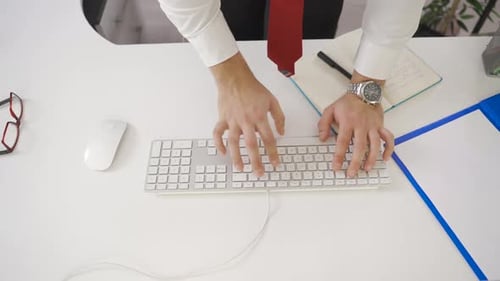 Young concentrated businessman is working in the office looking at the computer.