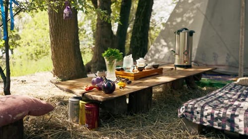 A wooden stand with bowls filled with water and cups of tea stands on table among greens vegetables