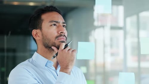 Man Brainstorming Ideas Using Sticky Notes in Office