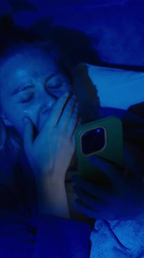 Tired Woman Scrolling Phone at Night