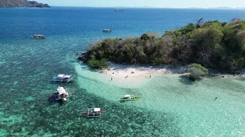 Aerial Dolly Out Over Tour Boats in Clear Water of Tropical CYC Island, Coron