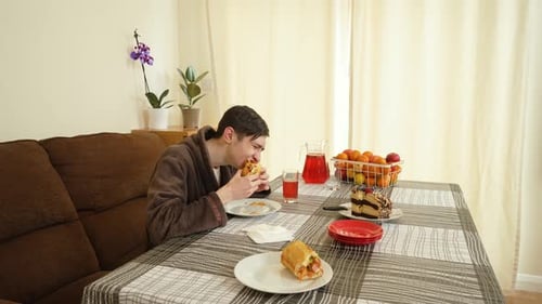 Young Adult Eating Sandwich at Dining Table