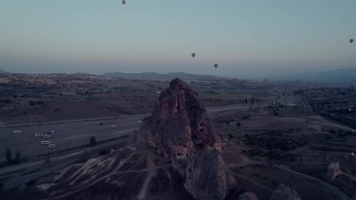 Cappadocia's rocky terrain with hot air balloons at sunrise