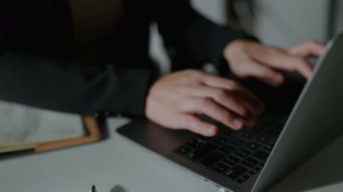 Young Professional Typing on Laptop in Modern Office