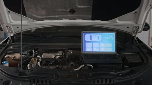 Laptop on Car Engine Shows Car Service Control Panel