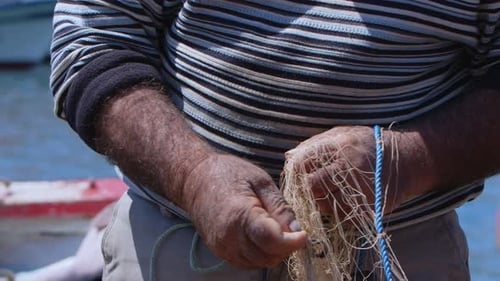 Fisherman Is Repairing Fishnets On Fishing Boat In Dock 19