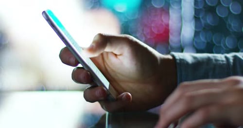 Hands Scroll on Mobile Phone at Night