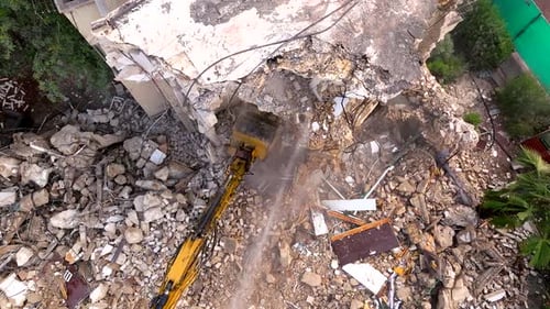 Excavator arm demolishing an old building, Aerial view