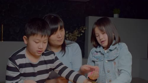 Cute Asian School Age Daughter Showing Handcraft Toy From Playdough to Mother