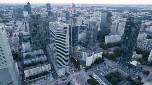 Aerial orbit over the downtown with office skyscrapers and residential buildings on sunset