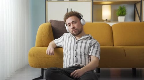 Unhappy man listening to music.