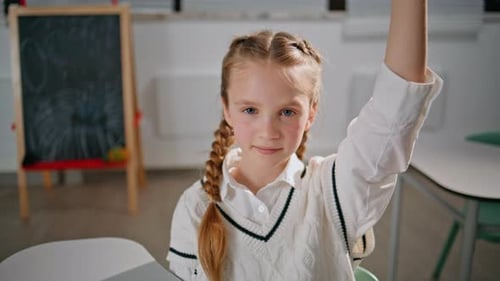 Schoolgirl Raises Hand in Classroom Lesson