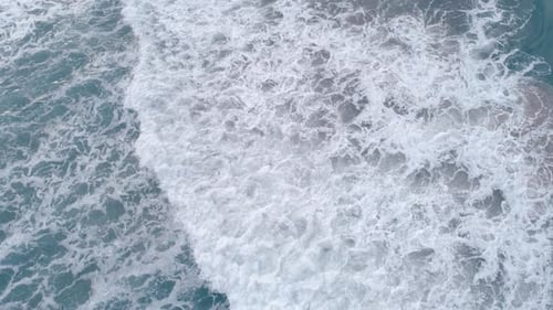 Top Down Aerial View of Giant Ocean Waves Crashing and Foaming