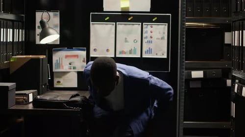 Young Adult Working at Desk with Laptop in Office