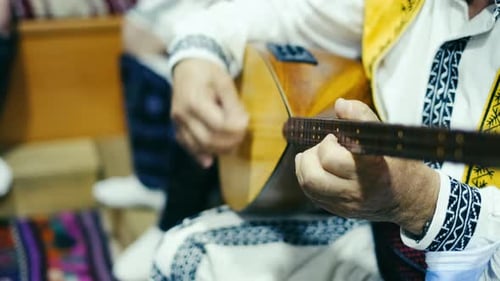 Man in ethnic clothes plays folkloric musical instrument. close-up shot. slow motion, 4K. 2
