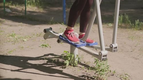 Woman Working Out on Outdoor Exercise Equipment in the Park
